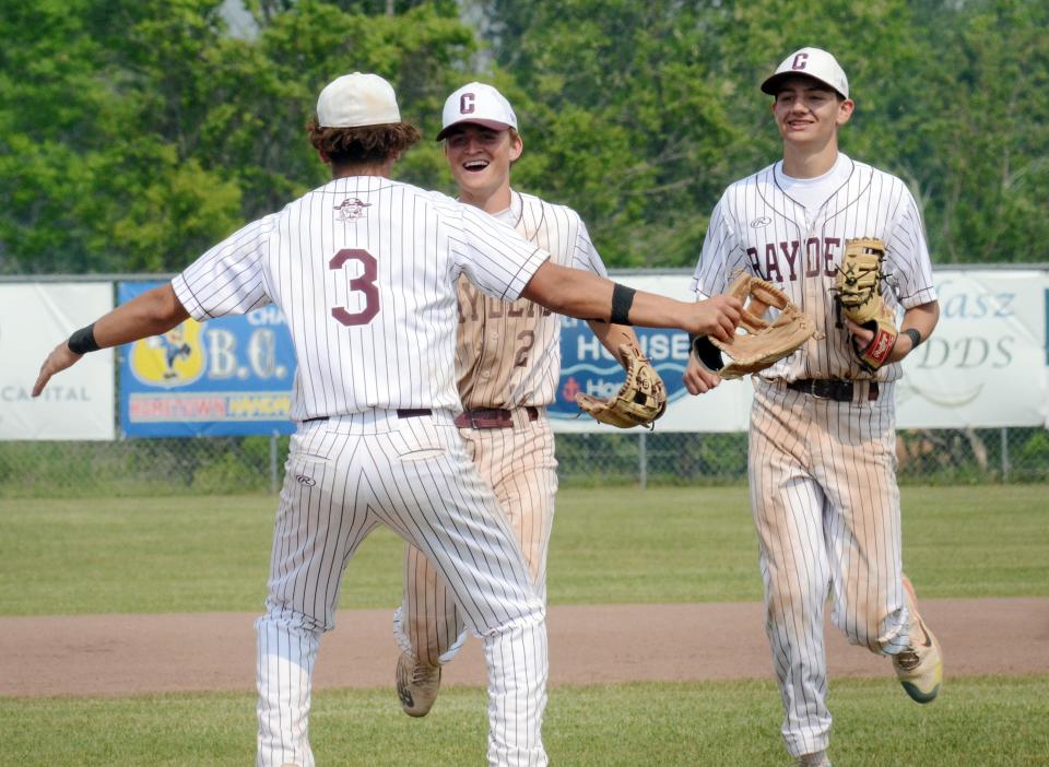Charlevoix pitcher Bryce Johnson (3) celebrates with Troy Nickel (2) as Owen Waha follows after Nickel made a diving out to end scoring chance for the Elks.