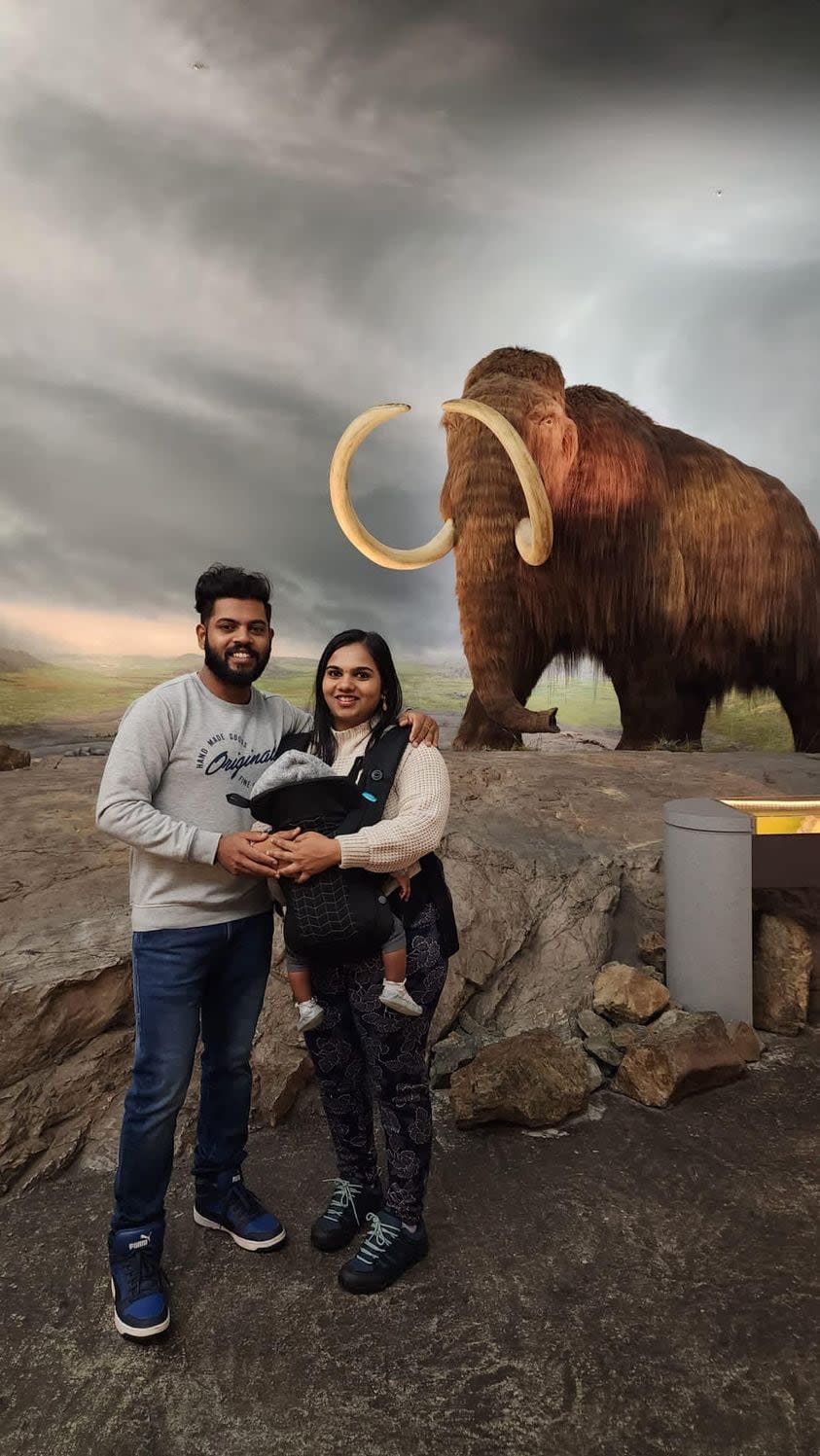 Burnaby husband Kumariah Shunmugavadivel and his wife Niranjana Kumariah pose with their infant in front of the wooly mammoth at the Royal B.C. Museum. The family use this eye-catching photo in posts when hunting for housing.