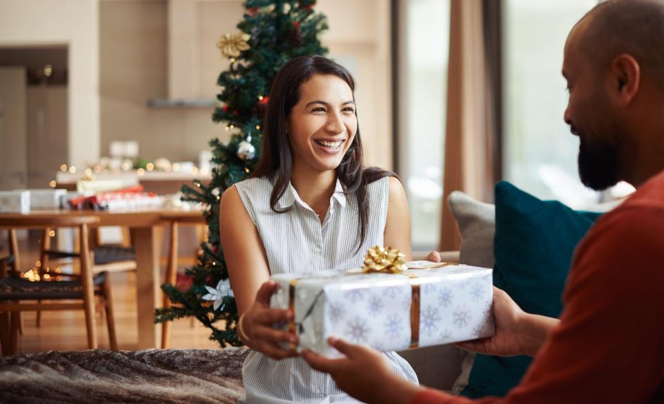 woman giving christmas gift to man