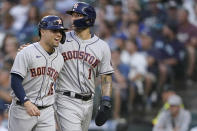 Houston Astros' Aledmys Diaz, left, and Carlos Correa head to the dugout after scoring on a double by Myles Straw during the fourth inning of a baseball game against the Seattle Mariners on Tuesday, July 27, 2021, in Seattle. (AP Photo/Ted S. Warren)