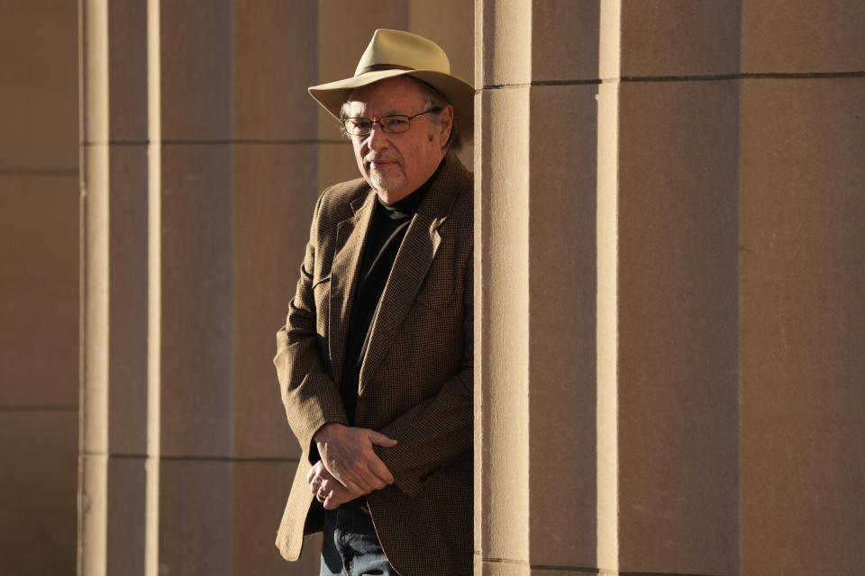 Max McCoy, the lone journalism professor at Emporia State University, poses for a photo in front of the school's administration building Wednesday, Jan. 4, 2023, in Emporia, Kan. McCoy was was one of 33 mostly tenured professors fired at the school using an emergency pandemic measure allowing universities to bypass regular policies covering terminations to balance budgets. (AP Photo/Charlie Riedel)