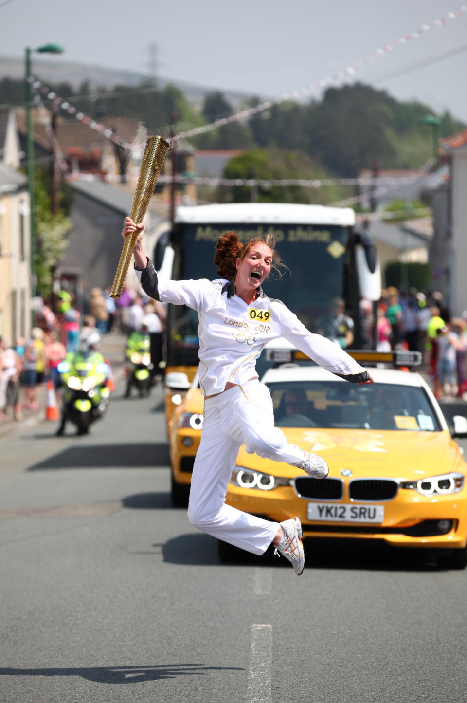 In this handout image provided by LOCOG, Synchronised swimmer Nadine Struijk of the Netherlands jumps while carrying the Olympic Torch on May 25, 2012 in Mrynmawr, Wales. The Olympic Torch is on the seventh day of it's journey around the United Kingdom which will involve 8,000 torchbearers covering 8,000 miles. (Photo by LOCOG via Getty Images)