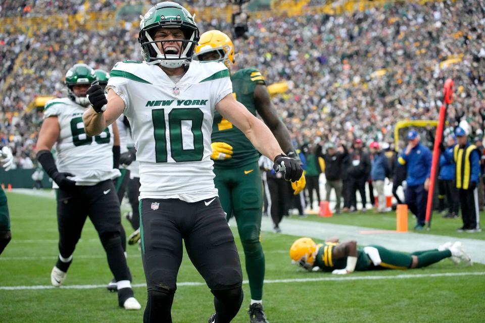 New York Jets wide receiver Braxton Berrios (10) celebrates after rushing in for a touchdown after eluding Green Bay Packers safety Adrian Amos (31), right,  during the third quarter of their game on Sunday, Oct. 16, 2022 at Lambeau Field in Green Bay.  