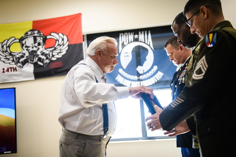 J.W. Johnson Sr. hands out framed gifts to the teammates of his late son, Sgt. 1st Class Jeremiah Johnson before a Group Support Battalion, 3rd Special Forces Group building dedication ceremony on Tuesday, Oct. 4, 2022. Sgt. 1st Class Jeremiah Johnson is one of the soldiers killed Oct. 4, 2017, in Niger. 