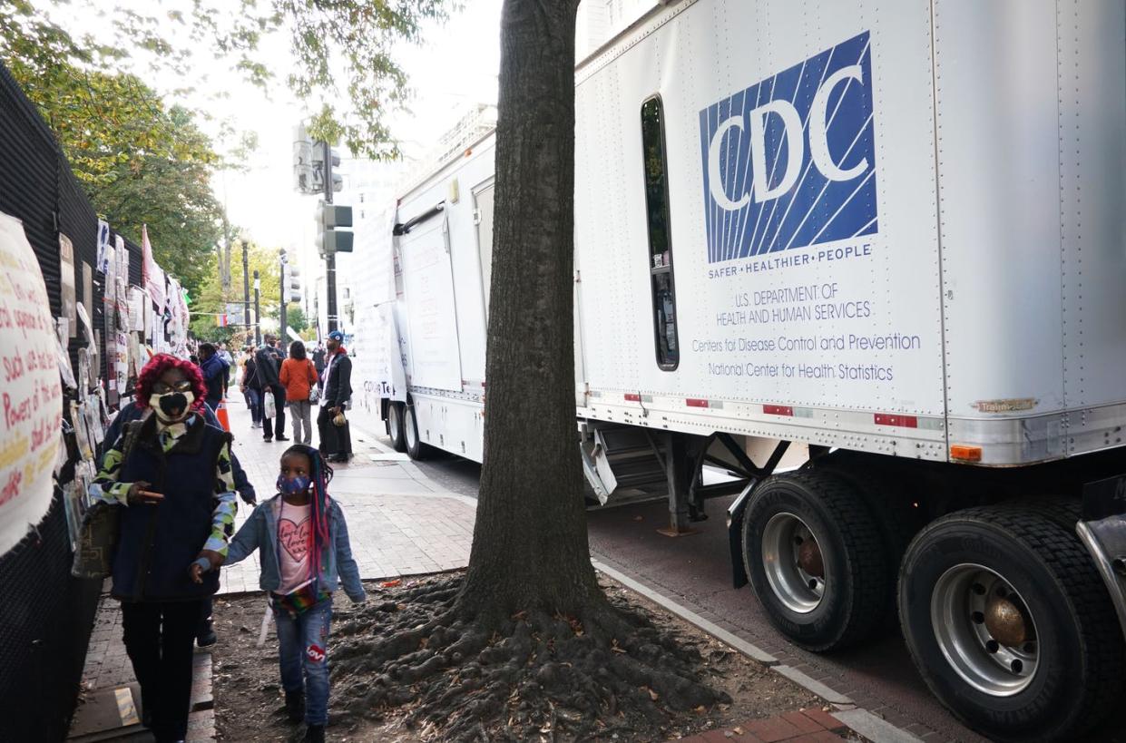 <span class="caption">The CDC has put out several conflicting messages of late, giving rise to concerns about trust.</span> <span class="attribution"><a class="link " href="https://www.gettyimages.com/detail/news-photo/people-walk-past-a-cdc-trailer-near-a-covid-19-testing-news-photo/1228984696?adppopup=true" rel="nofollow noopener" target="_blank" data-ylk="slk:Photo by MANDEL NGAN/AFP via Getty Images;elm:context_link;itc:0;sec:content-canvas">Photo by MANDEL NGAN/AFP via Getty Images</a></span>