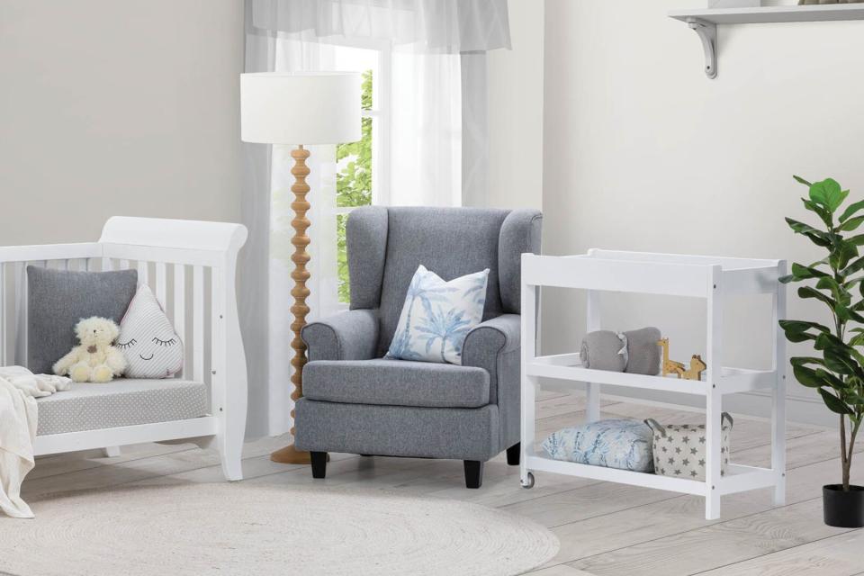 The Samuel Nursery Chair and Ottoman in child's nursery beside cot and change table