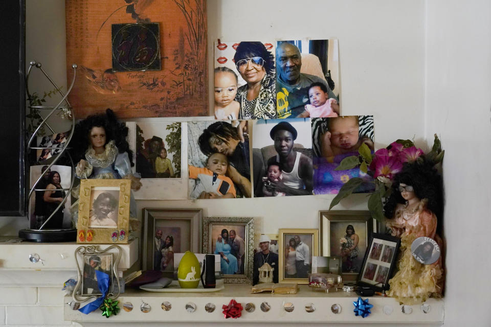 Family photos sit on a mantle in the South Side Chicago home of Michael Williams and his wife, Jacqueline Anderson, on Tuesday, July 27, 2021. (AP Photo/Charles Rex Arbogast)