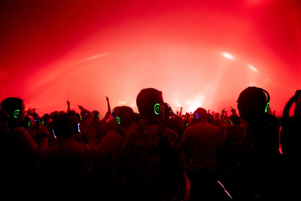 People dance to music played from headphones during a silent disco on the first day of Bonnaroo in Manchester, Tenn., Friday, June 17, 2022.