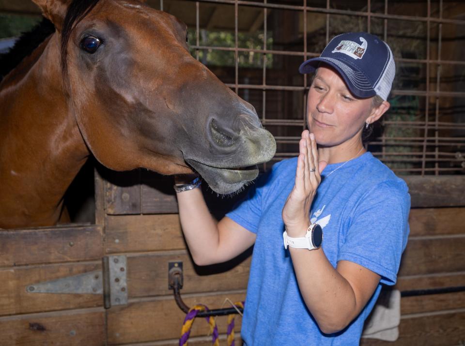 Nicole Spencer, executive director of Heroes In Transition, pets Soleil Aug. 3 at the FIT Camp at Alliance Equestrian Center in Sandwich. Sophie Proe/Cape Cod Times