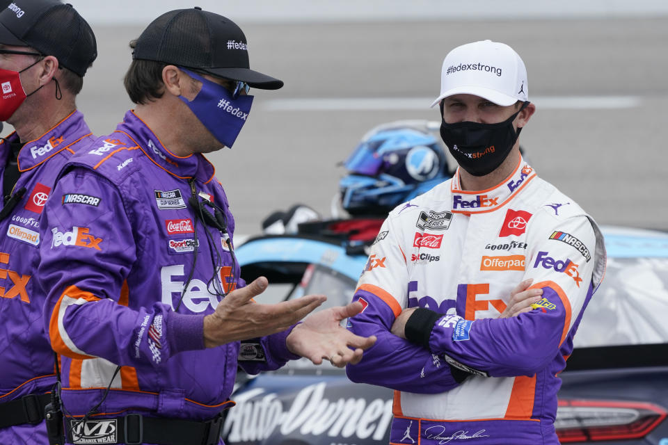 Denny Hamlin, right, talks to a crew member prior to the start of the NASCAR Cup Series auto race at Richmond International Raceway in Richmond, Va., Sunday, April 18, 2021. (AP Photo/Steve Helber)