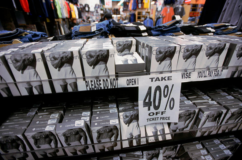 A store display showing numerous boxes of Calvin Klein men's underwear. A prominent sign advertises a 40% discount on the ticket price