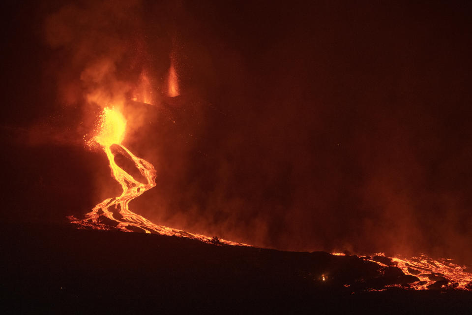 Lava flows from a volcano on the Canary island of La Palma, Spain in the early hours of Tuesday Sept. 28, 2021. A Spanish island volcano that has buried more than 500 buildings and displaced over 6,000 people since last week lessened its activity on Monday, although scientists warned that it was too early to declare the eruption phase finished and authorities ordered residents to stay indoors to avoid the unhealthy fumes from lava meeting sea waters. (AP Photo/Saul Santos)