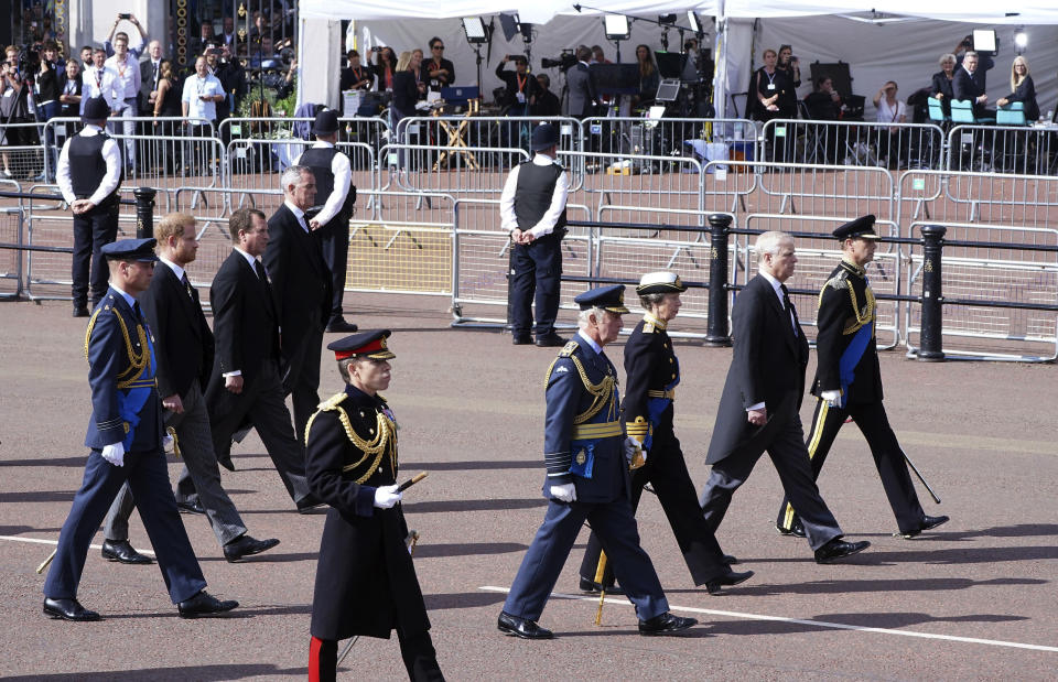 FILE - The media inside tents can be seen in backgroung as Britain's King Charles III, Princess Anne, Prince Andrew, Prince Edward, Prince William, Prince Harry and Peter Phillips follow the coffin of Queen Elizabeth II, draped in the Royal Standard with the Imperial State Crown placed on top, as it is carried on a horse-drawn gun carriage of the King's Troop Royal Horse Artillery, during the ceremonial procession from Buckingham Palace to Westminster Hall, London, where it will lie in state ahead of her funeral on Monday. Plans by news organizations that have been in place for years — even decades — to cover the death of Queen Elizabeth II were triggered and tested when the event took place. London has been inundated with journalists, with more headed to the city for the funeral services on Monday. (Ian West/Pool Photo via AP, File)