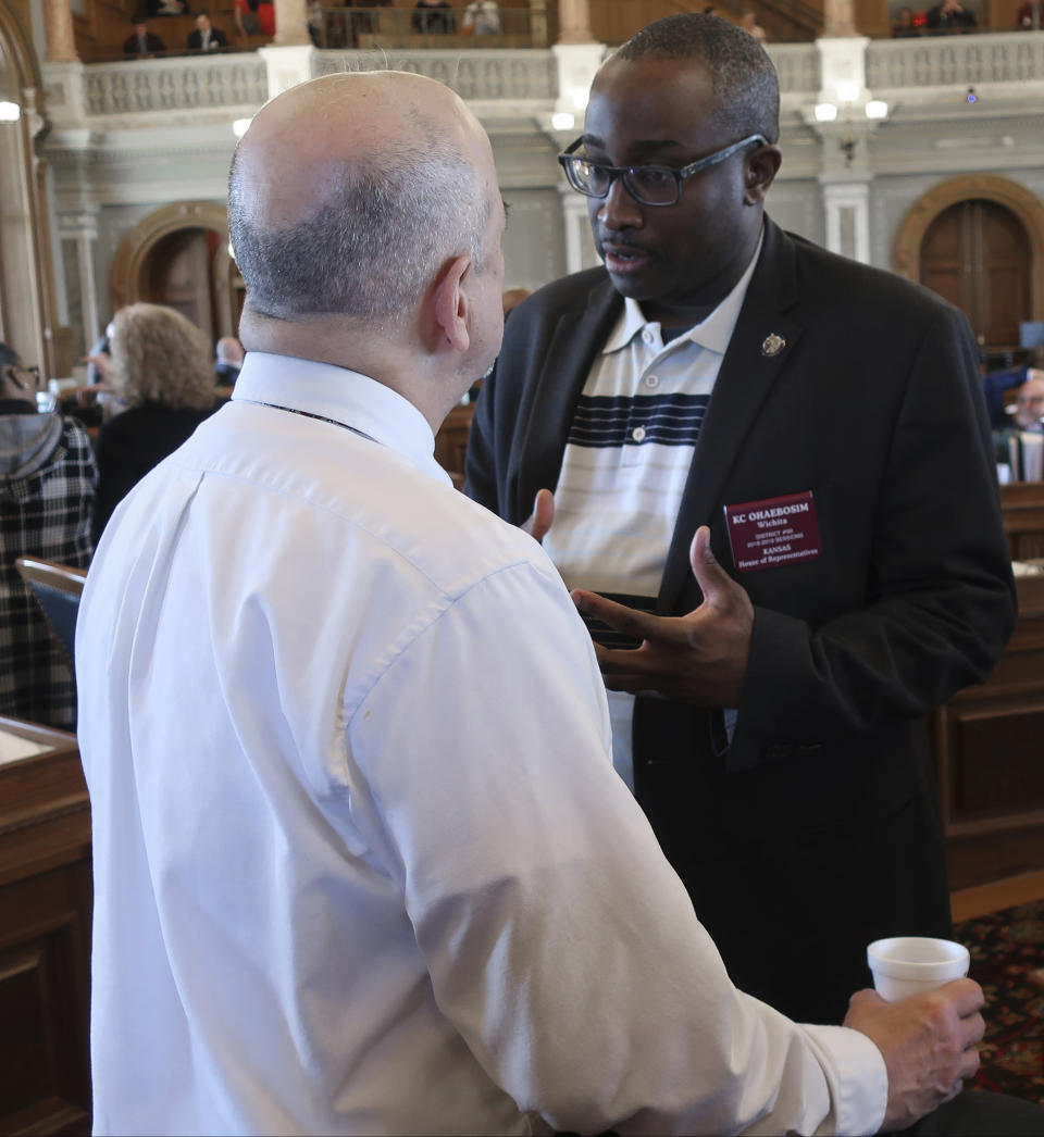 Kansas state Rep. K.C. Ohaebosim,, D-Wichita, right, confers with House Minority Leader Tom Sawyer, also D-Wichita, while the House waits for a debate on a proposed budget, Saturday, May 4, 2019, at the Statehouse in Topeka, Kan. Democrats and moderate Republicans were holding up the budget in the House in hopes of forcing a debate on Medicaid expansion in the Senate. (AP Photo/John Hanna)