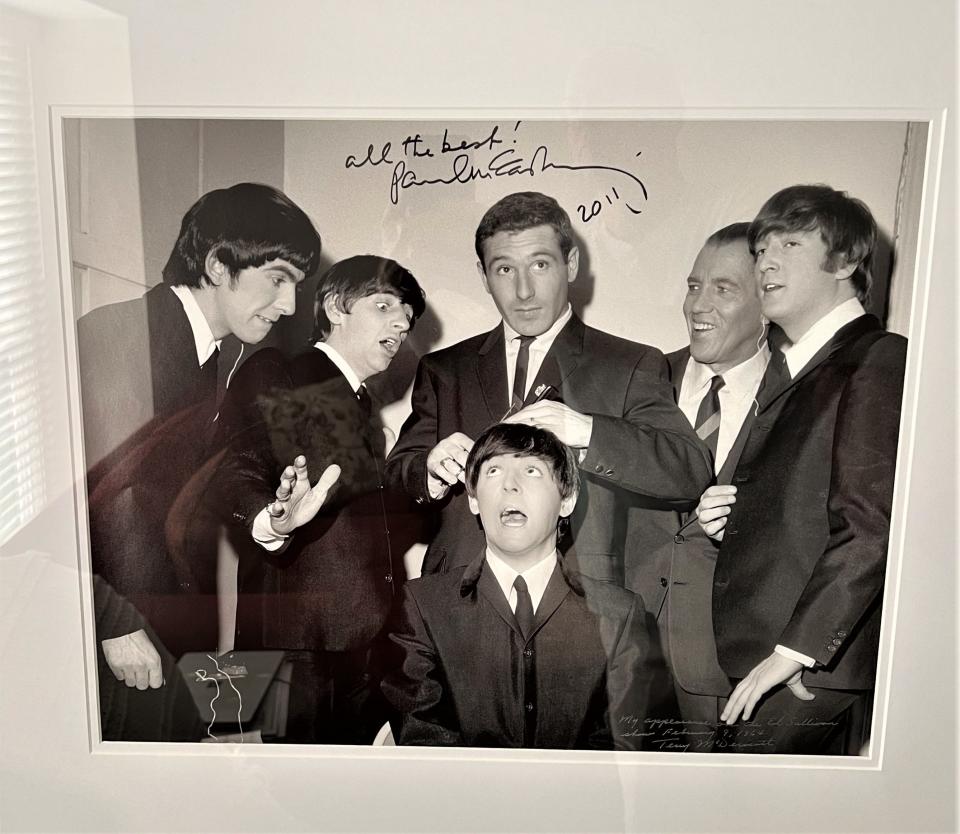 Olympic gold medalist Terry McDermott, center, poses with the Beatles backstage at "The Ed Sullivan Show" in February 1964. McDermott kept this framed copy signed by Paul McCartney at his home.