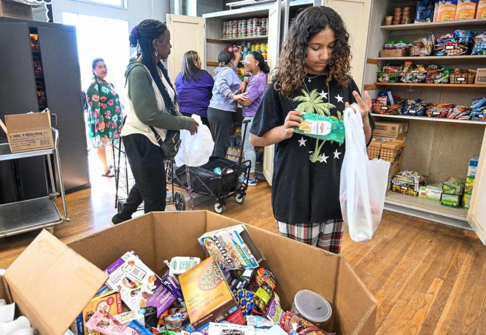 Naila Sightler, right, a Fort Miller Middle School seventh grade transfer student, packs up food during the School’s Community School Food Pantry & Clothing Closet event at the Fresno school on Friday, March 8, 2024. CRAIG KOHLRUSS/ckohlruss@fresnobee.com