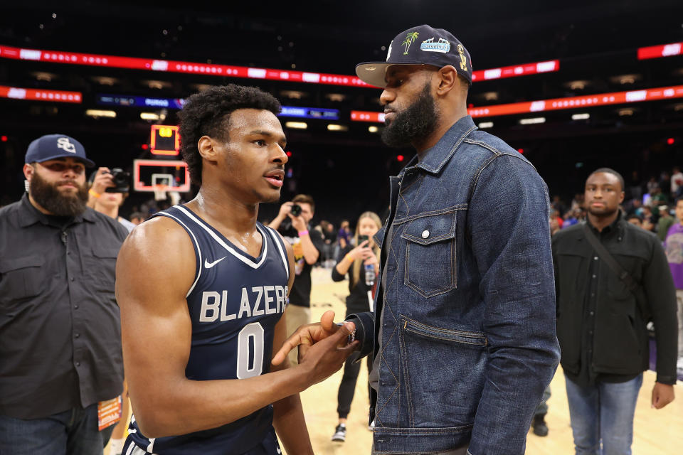 PHOENIX, ARIZONA - DECEMBER 11: Bronny James
#0 of the Sierra Canyon Trailblazers is greeted by his father and NBA player LeBron James after defeating the the Perry Pumas in the Hoophall West tournament at Footprint Center on December 11, 2021 in Phoenix, Arizona. (Photo by Christian Petersen/Getty Images)