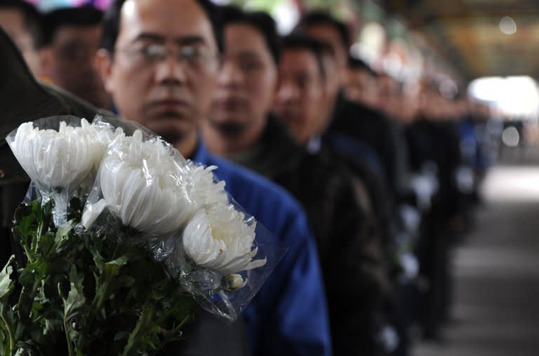 Villagers queue to pay their respects to retired local Communist Party chief Wu Renbao at his home in Huaxi village on March 19, 2013. Residents of China's "richest village" bid farewell to the man who made Huaxi a socialist paradise, with a 20-vehicle funeral procession transporting his coffin and a helicopter flying overhead