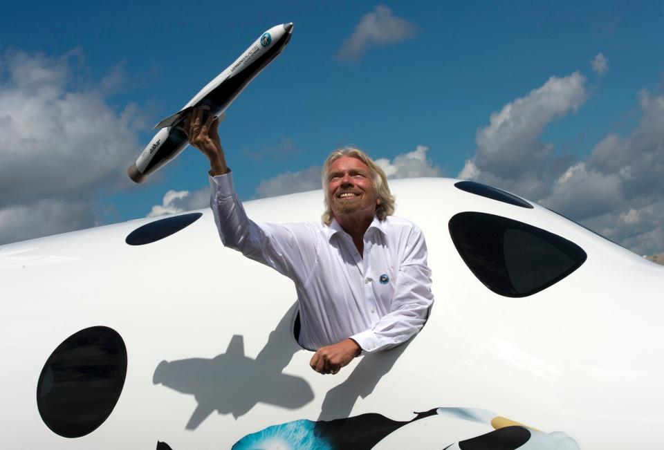 Richard Branson steht im Fenster einer Nachbildung seiner Virgin Galactic, die das erste Raumschiff werden soll, mit dem man Flüge ins Weltall buchen kann.