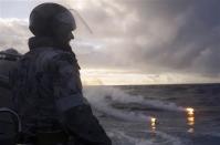 Standing in a rigid hull inflatable boat launched from the Australian Navy ship HMAS Perth, Boatswain's Mate, Able Seaman Morgan Macdonald observes markers dropped from a Royal New Zealand Air Force (RNZAF) P3K Orion after an object was sighted in the southern Indian Ocean during the continuing search for the missing Malaysian Airlines flight MH370 in this picture released by the Australian Defence Force April 17, 2014. REUTERS/Australian Defence Force/Handout via Reuters