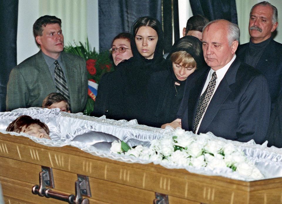 FILE - Former Soviet President Mikhail Gorbachev stands with daughter Irina and granddaughter Krenia, foreground third right, as they grieve before the coffin with Raisa Gorbachev's body at Russia's Culture Fund in Moscow Wednesday, Sept. 22, 1999. Raisa Gorbachev died Monday at age 67 in Muenster, Germany, where she had been treated for leukemia for two months. Right in the background is prominent Russian film director Nikita Mikhalkov. When Mikhail Gorbachev is buried Saturday at Moscow's Novodevichy Cemetery, he will once again be next to his wife, Raisa, with whom he shared the world stage in a visibly close and loving marriage that was unprecedented for a Soviet leader. Gorbachev's very public devotion to his family broke the stuffy mold of previous Soviet leaders, just as his openness to political reform did. (AP Photo/Misha Japaridze, File)