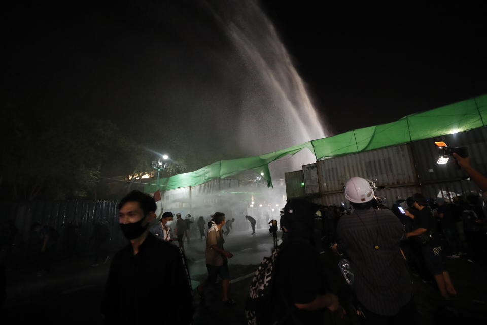 Police security use water cannons to disperse protesters who removed container vans used as a barricade in front of the Grand Palace Saturday, Mar. 20, 2021 in Bangkok, Thailand. Thailand's student-led pro-democracy movement is holding a rally in the Thai capital, seeking to press demands that include freedom for their leaders, who are being held without bail on charges of defaming the monarchy. (AP Photo/Sakchai Lalit)