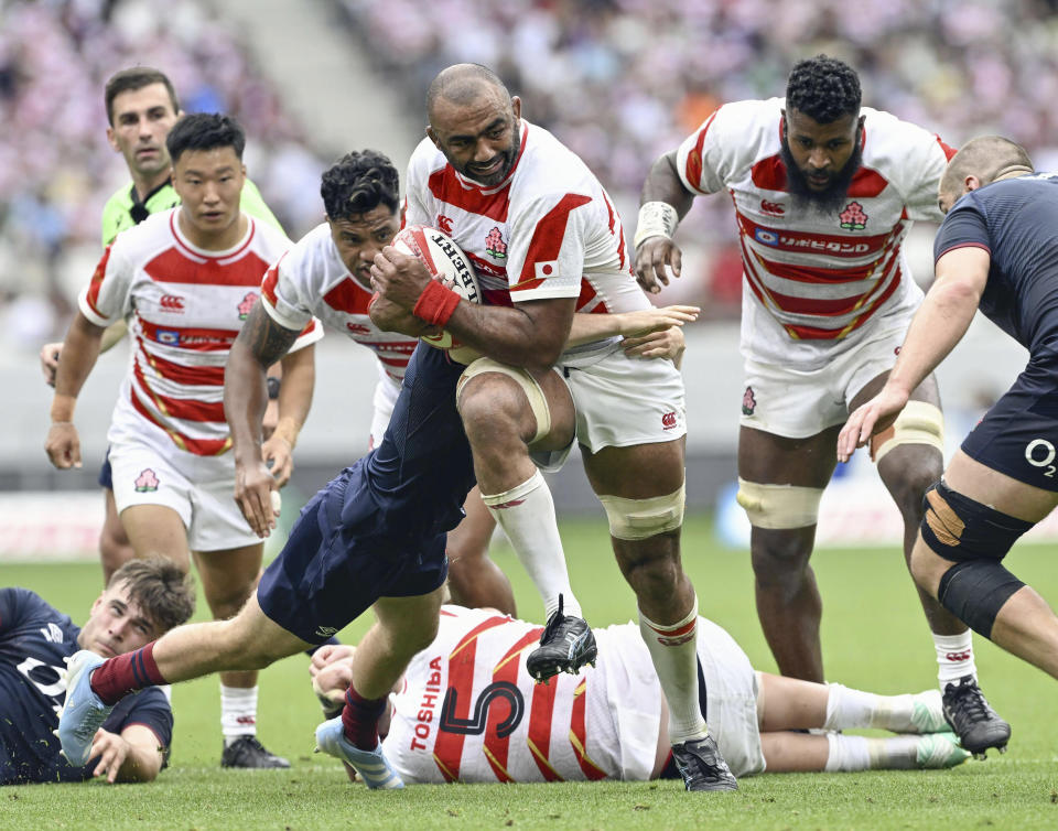 Japan’s Michael Leitch runs with the ball against England’s defense during a rugby test match in Tokyo, Japan, Saturday, June 22, 2024. England's stop in Tokyo on its way to a two-test rugby tour of New Zealand was no contest as the visitors beat Japan 52-17 Saturday in an eight-try performance at the National Stadium in Tokyo. (Kyodo News via AP)