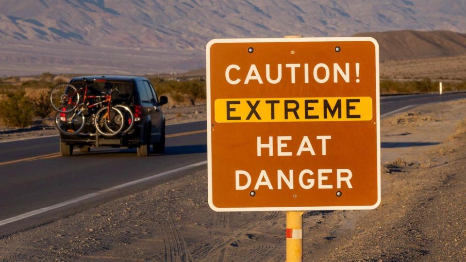 PHOTO: A car passes a sign warning of extreme heat danger on the eve of a day that could set a new world heat record in Death Valley National Park, July 15, 2023, near Furnace Creek, Calif. (David Mcnew/Getty Images)