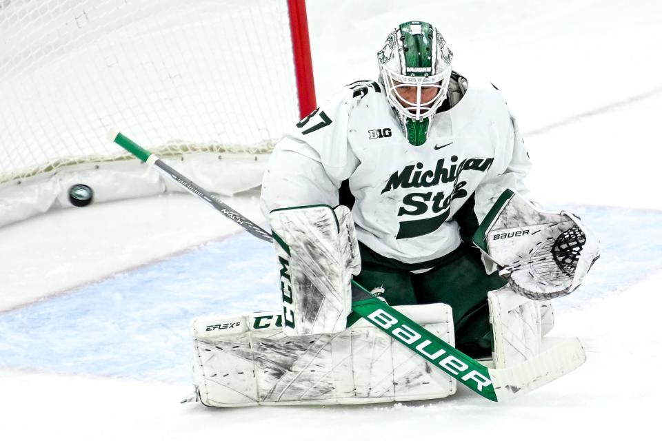 Michigan State's Dylan St. Cyr deflects a puck shot by Michigan during the first period on Friday, Dec. 9, 2022, at Munn Arena in East Lansing.