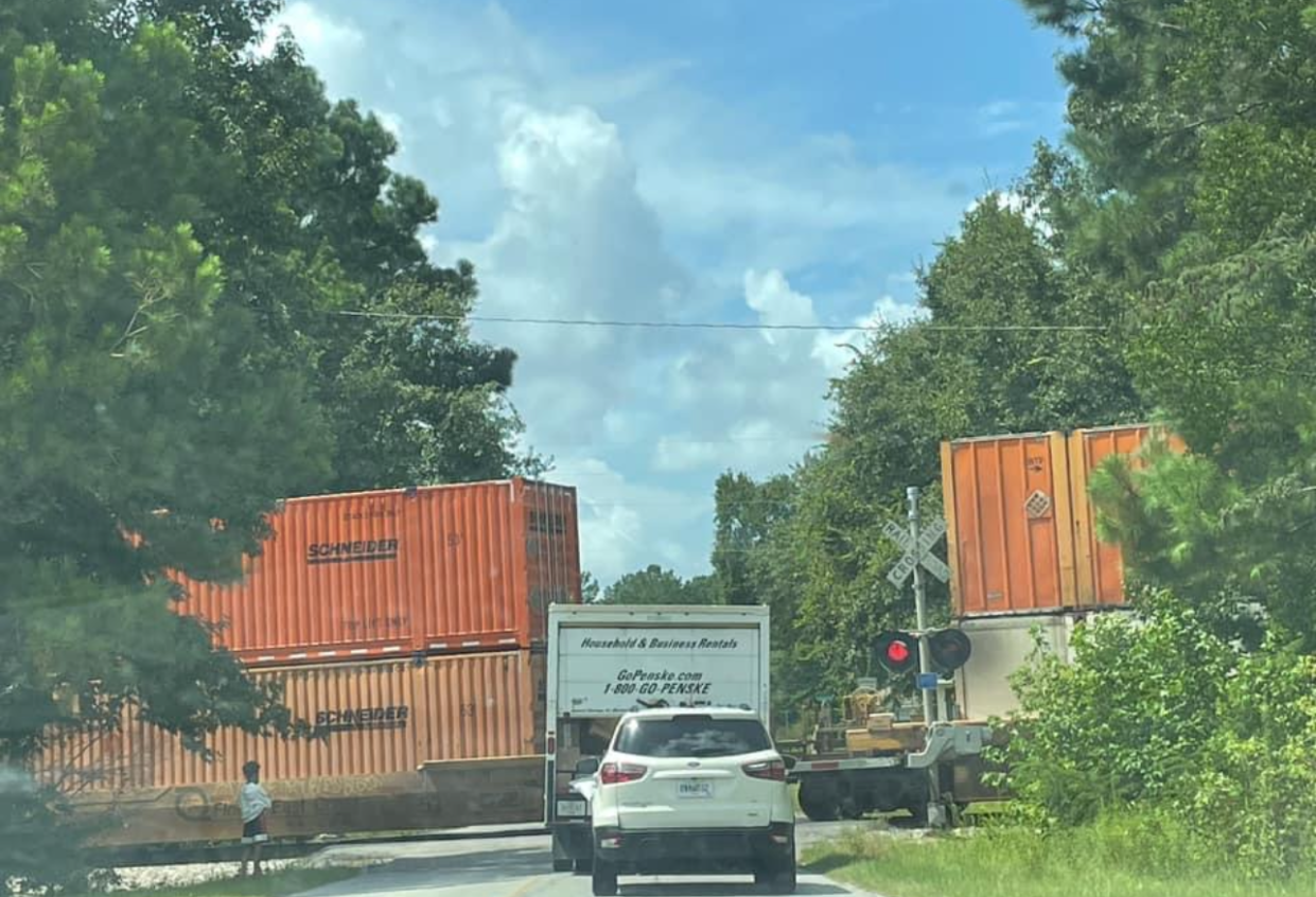 A train stalled in front of the Picket Fences subdivision is photographed.