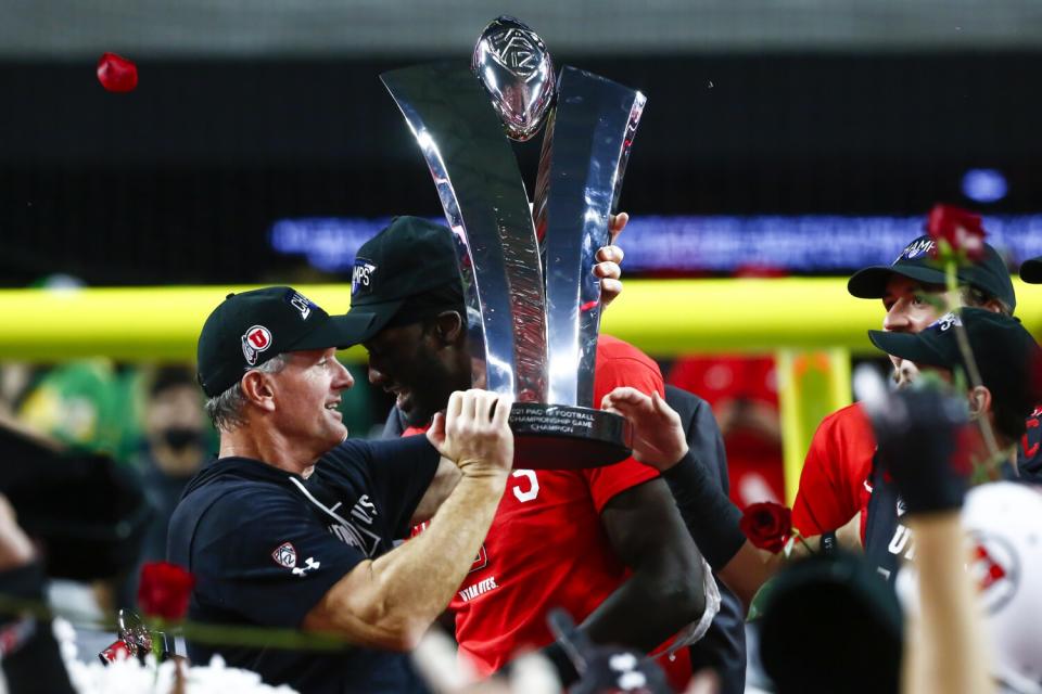 Utah coach Kyle Whittingham raises the Pac-12 championship trophy after beating Oregon in Las Vegas on Dec. 3.