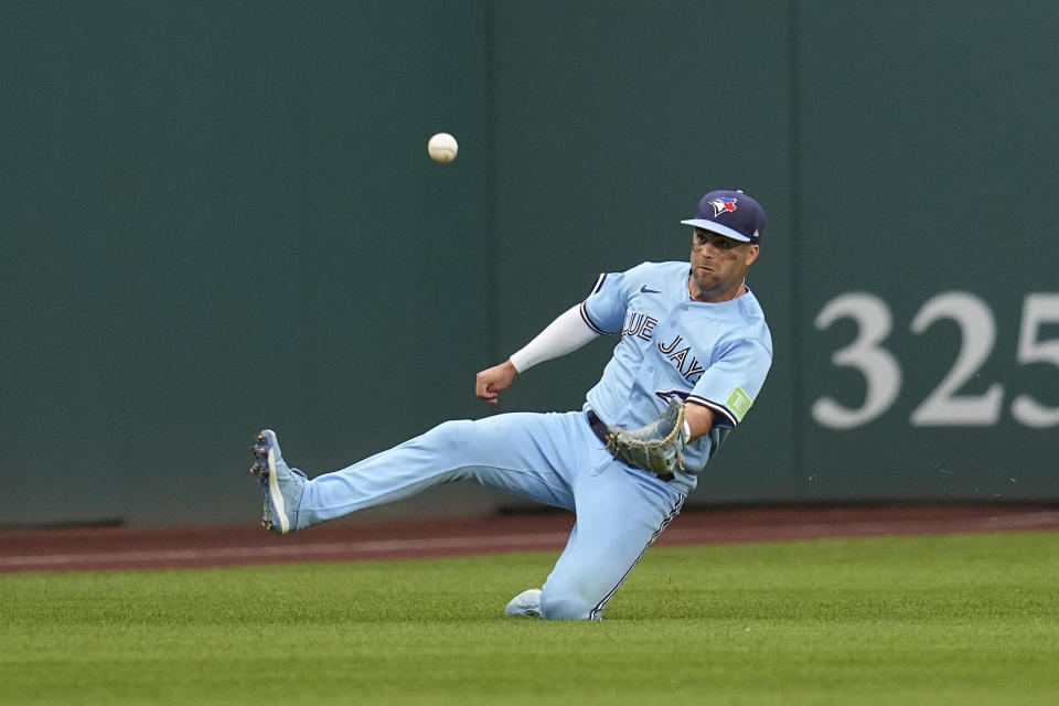 Toronto Blue Jays left fielder Whit Merrifield slides to catch a fly ball hit by Cleveland Guardians' Andres Gimenez during the third inning of a baseball game Wednesday, Aug. 9, 2023, in Cleveland. (AP Photo/Sue Ogrocki)