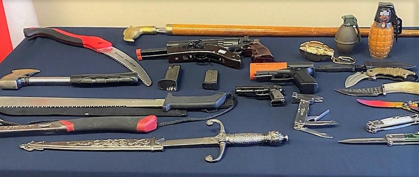 A collection of weapons found at TSA's Jacksonville airport checkpoint, from swords and saws to real and replica handguns and fake grenades.