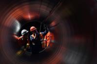 FILE PHOTO: Workers are seen through a pipe at the construction site of the Nord Stream 2 gas pipeline in Russia