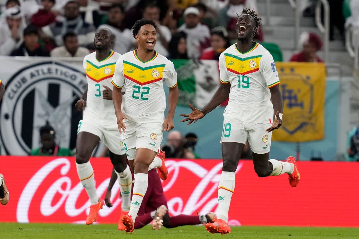 Senegal’s Famara Diedhiou, right, celebrates after scoring his side’s second goal against World Cup hosts Qatar (Thanassis Stavrakis/AP) (AP)