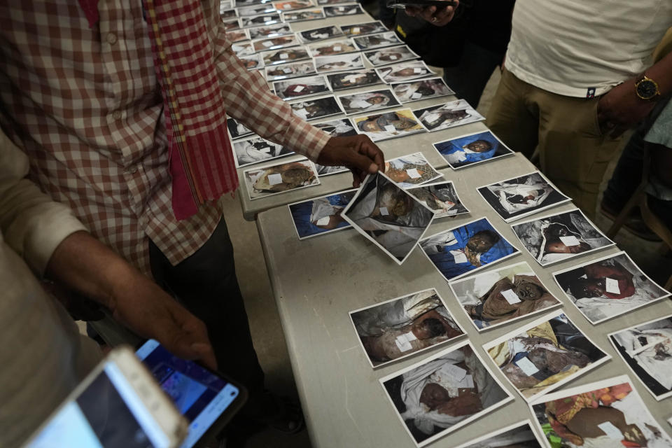 Relatives look at the photographs of unidentified bodies of passengers displayed for identification, in Balasore district, in the eastern Indian state of Orissa, Sunday, June 4, 2023. Indian authorities end rescue work and begin clearing mangled wreckage of two passenger trains that derailed in eastern India, killing over 300 people and injuring hundreds in one of the country’s deadliest rail crashes in decades. (AP Photo/Rafiq Maqbool)
