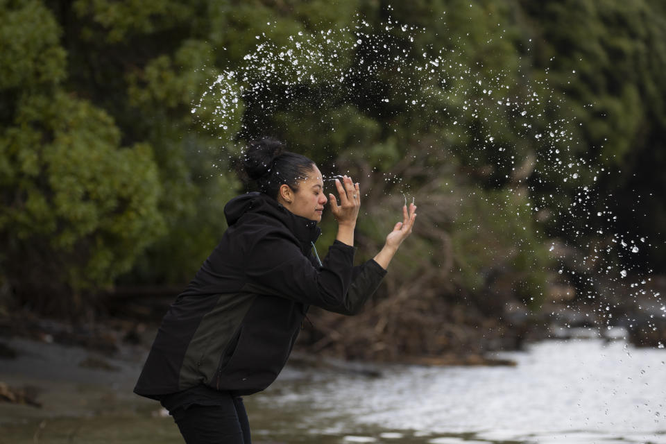 Ngahuia Twomey-Waitai, 28, reaches into New Zealand's Whanganui River to ritually splash water on herself on June 17, 2022. “I tend to come down here quite often to cleanse myself, especially when I’m going through some big, huge changes in my life, regardless of them being good or bad," she says. “The river always makes things better for me." “Just being down here gives me a huge smile and brings me at peace with myself and my life.” (AP Photo/Brett Phibbs)