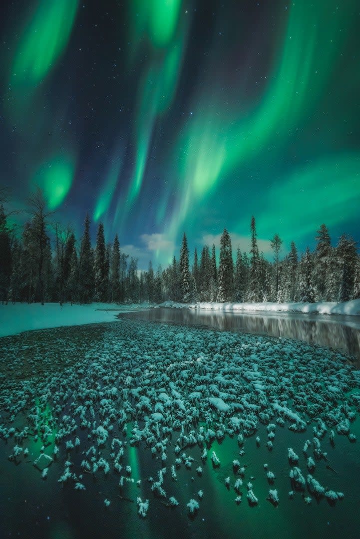 A frozen water body beneath the aurora in Finland.