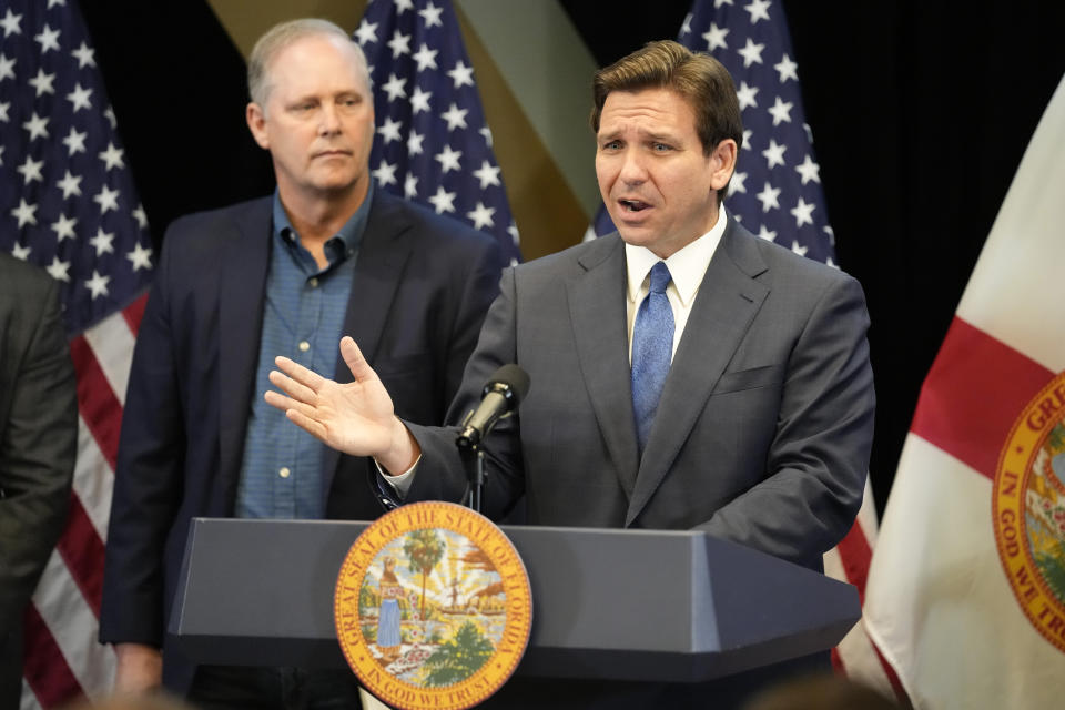 Florida Gov. Ron DeSantis, right, speaks at a news conference as Wilton Simpson, Commissioner of Agriculture listens, at the Reedy Creek Administration Building Monday, April 17, 2023, in Lake Buena Vista, Fla. DeSantis and Florida lawmakers ratcheted up pressure on Walt Disney World on Monday by announcing legislation that will use the regulatory powers of Florida government to exert unprecedented oversight on the park resort's rides and monorail. (AP Photo/John Raoux)