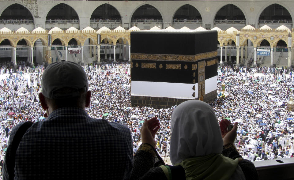 Muslim pilgrims pray as they watch thousands of pilgrims circumambulate around the Kaaba, the cubic building at the Grand Mosque, ahead of the Hajj pilgrimage in the Muslim holy city of Mecca, Saudi Arabia, Friday, Aug. 9, 2019. Hundreds of thousands of Muslims have arrived in the kingdom to participate in the annual hajj pilgrimage, a ritual required of all able-bodied Muslims at least once in their life. (AP Photo/Amr Nabil)