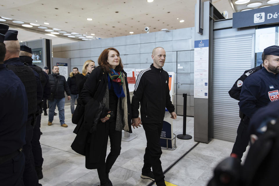 Palestinian French lawyer and activist Salah Hammouri walks with his wife Elsa Lefort as he arrives at the Charles de Gaulle Airport after his extradition from Israel to France, Sunday, Dec. 18, 2022, in Paris. Israel said it deported Hammouri to France early Sunday, claiming he has ties to a banned militant group, despite objections from the French government. (AP Photo/Lewis Joly)