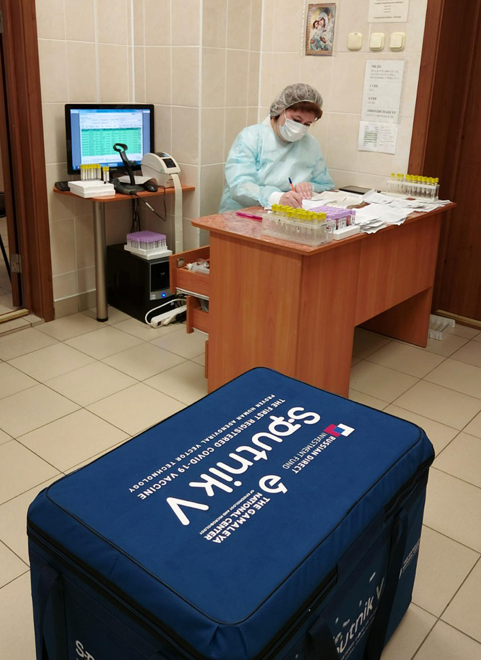 In this handout photo released by Belarus Health Ministry, Belarus medical worker works with the documentation of the Russia's Sputnik V coronavirus vaccine in Minsk, Belarus, Tuesday, Dec. 29, 2020. Belarus has announced the start of mass coronavirus vaccinations with the Russian-developed Sputnik V shot, becoming the second country after Russia to roll out the vaccine that is still undergoing late-stage studies to ensure its safety and efficacy. (Julia Borodun/ Belarus Health Ministry via AP)