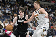 Memphis Grizzlies forward Jake LaRavia (3) handles the ball against Denver Nuggets center Nikola Jokic (15) in the first half of an NBA basketball game Sunday, April 14, 2024, in Memphis, Tenn. (AP Photo/Brandon Dill)