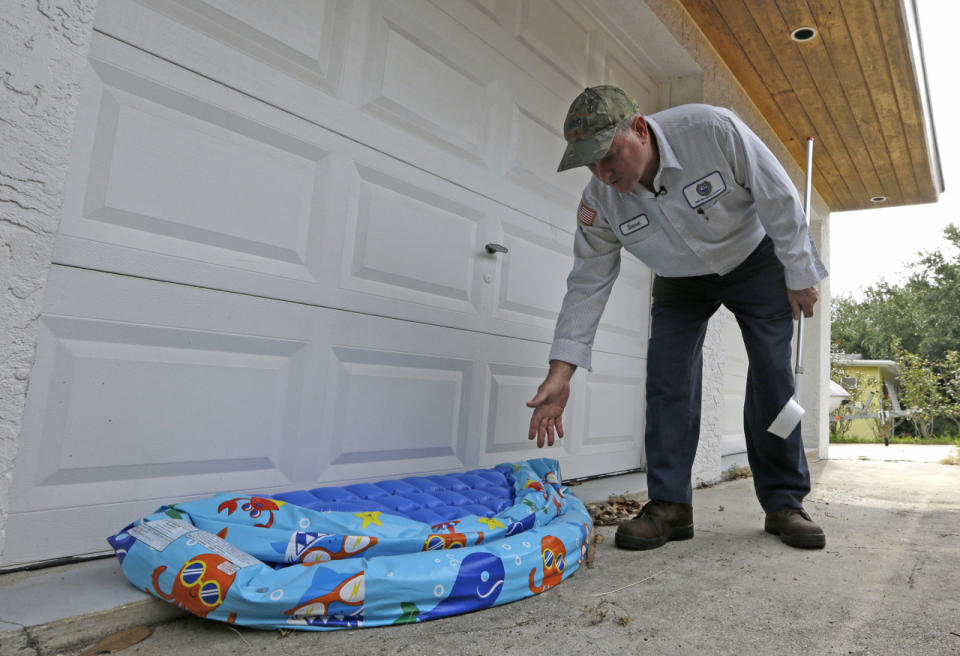 <p>Steve Noe, Martin County mosquito specialist, points to a beach inflatable where water can accumulate and become a breeding place for mosquitos, during an inspection outside a home in Rio, Fla., on May 12, 2016. (AP Photo/Alan Diaz)</p>