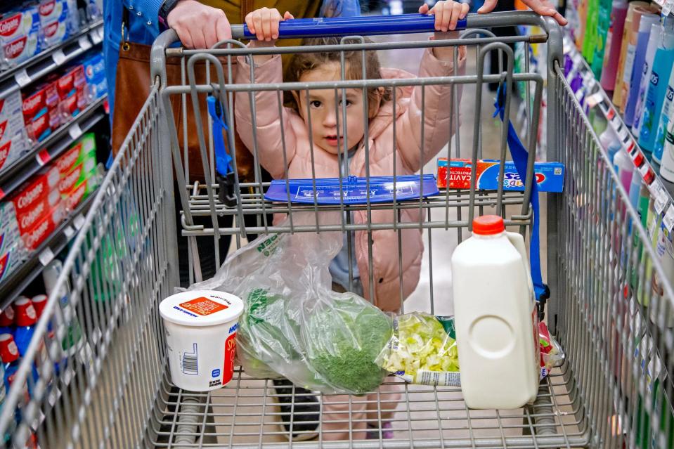 Skye Reid, 3, pushes the cart while grocery shopping with her mother Mollie Reid in Oklahoma City.
