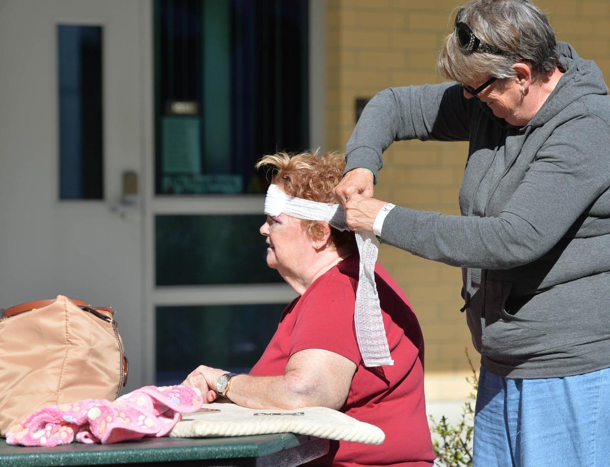 Cindy Royds, right, changes the bandage for his sister, Peggy Rappenecker, Monday morning, Oct. 3, 2022 at the Venice High School hurricane shelter in Venice, Florida. Rappenecker went back to her home in North Port to get supplies and check on her cat, when she fell in the kitchen, resulting in nine stitches and a shiner on her left eye. "It could have been a lot worse." Rappenecker said. 