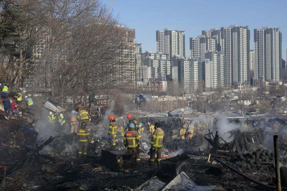 Firefighters and rescue workers clean up the site of a fire at Guryong village in Seoul, South Korea, Friday, Jan. 20, 2023. A fire spread through a neighborhood of densely packed, makeshift homes in South Korea's capital Friday morning. (AP Photo/Ahn Young-joon)