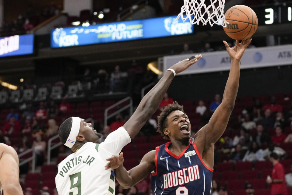 Houston Rockets forward Jae'Sean Tate, right, shoots as Milwaukee Bucks center Bobby Portis (9) defends during the first half of an NBA basketball game, Friday, Dec. 10, 2021, in Houston. (AP Photo/Eric Christian Smith)