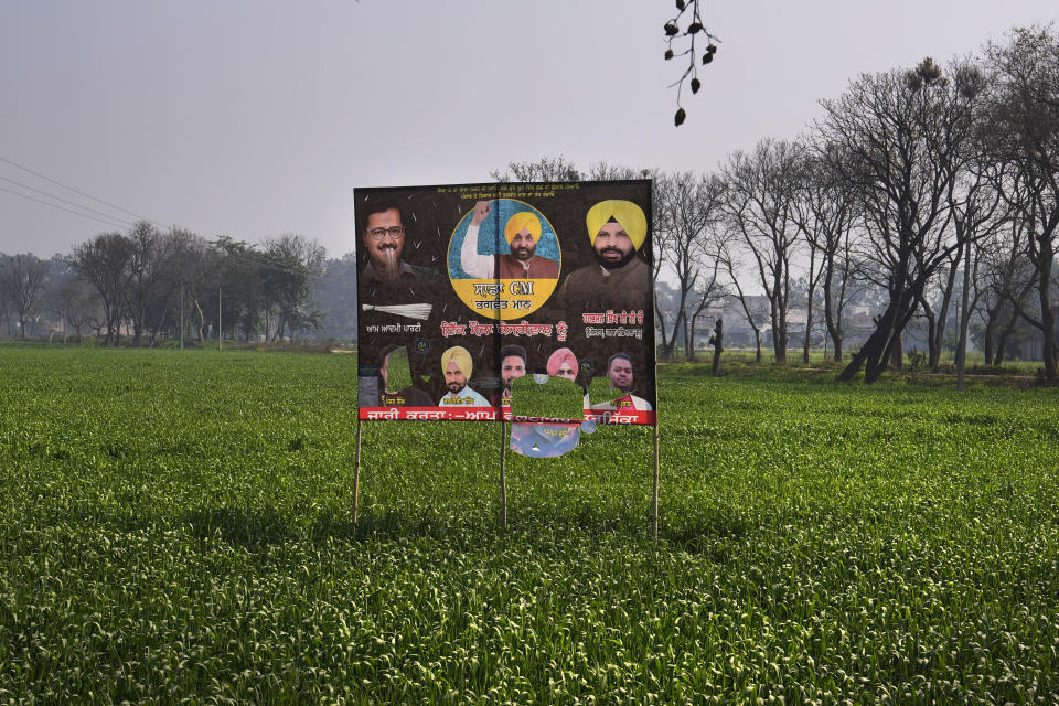 An election banner of Aam Aadmi Party is seen placed in the middle of wheat fields on the outskirts of Amritsar, in Indian state of Punjab, Tuesday, Feb. 15, 2022. India's Punjab state will cast ballots on Sunday that will reflect whether Indian Prime Minister Narendra Modi's ruling Bharatiya Janata Party has been able to neutralize the resentment of Sikh farmers by repealing the contentious farm laws that led to year-long protests. (AP Photo/Manish Swarup)