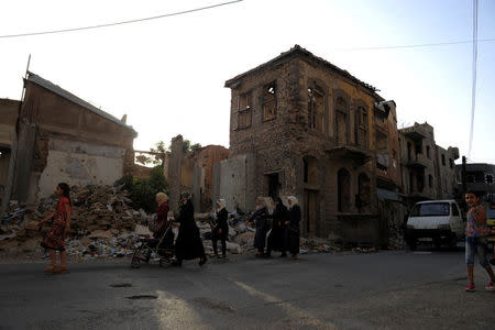 Women walk past the rubble of damaged buildings in the old city of Homs, Syria July 27, 2017. Picture taken July 27, 2017. REUTERS/Omar Sanadiki